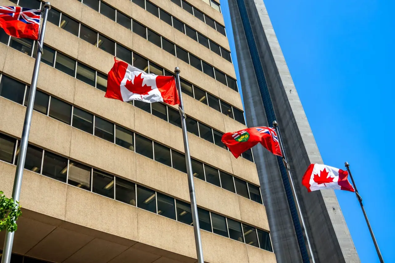 Canadian and Ontario flags on poles in front of an office building